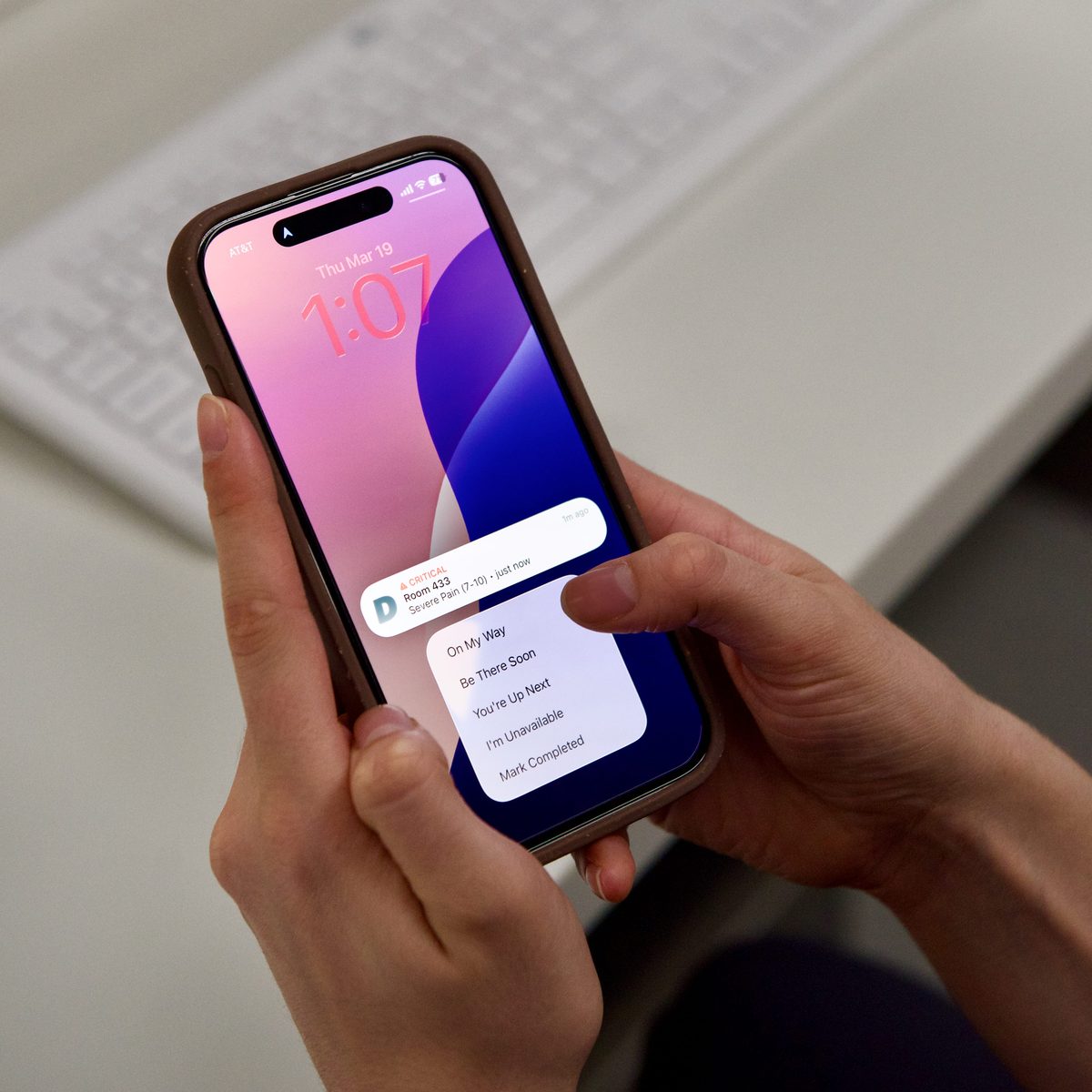 Hand holding an iPhone with a Dispatch critical alert.