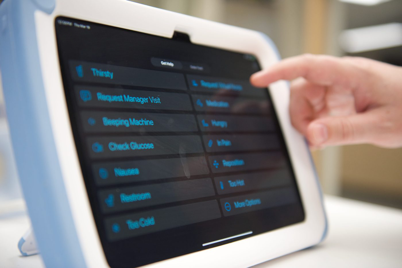 Patient pressing a request on the Dispatch bedside tablet.